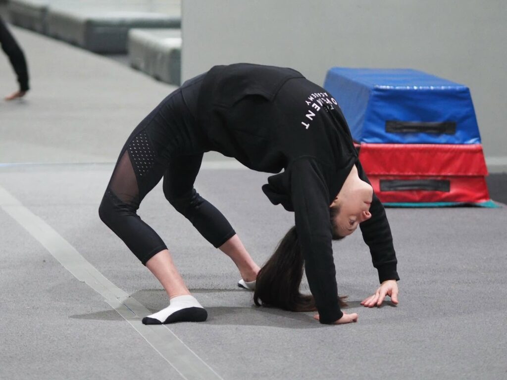 Person performing a deep backbend during flexibility training at The Movement Academy.
